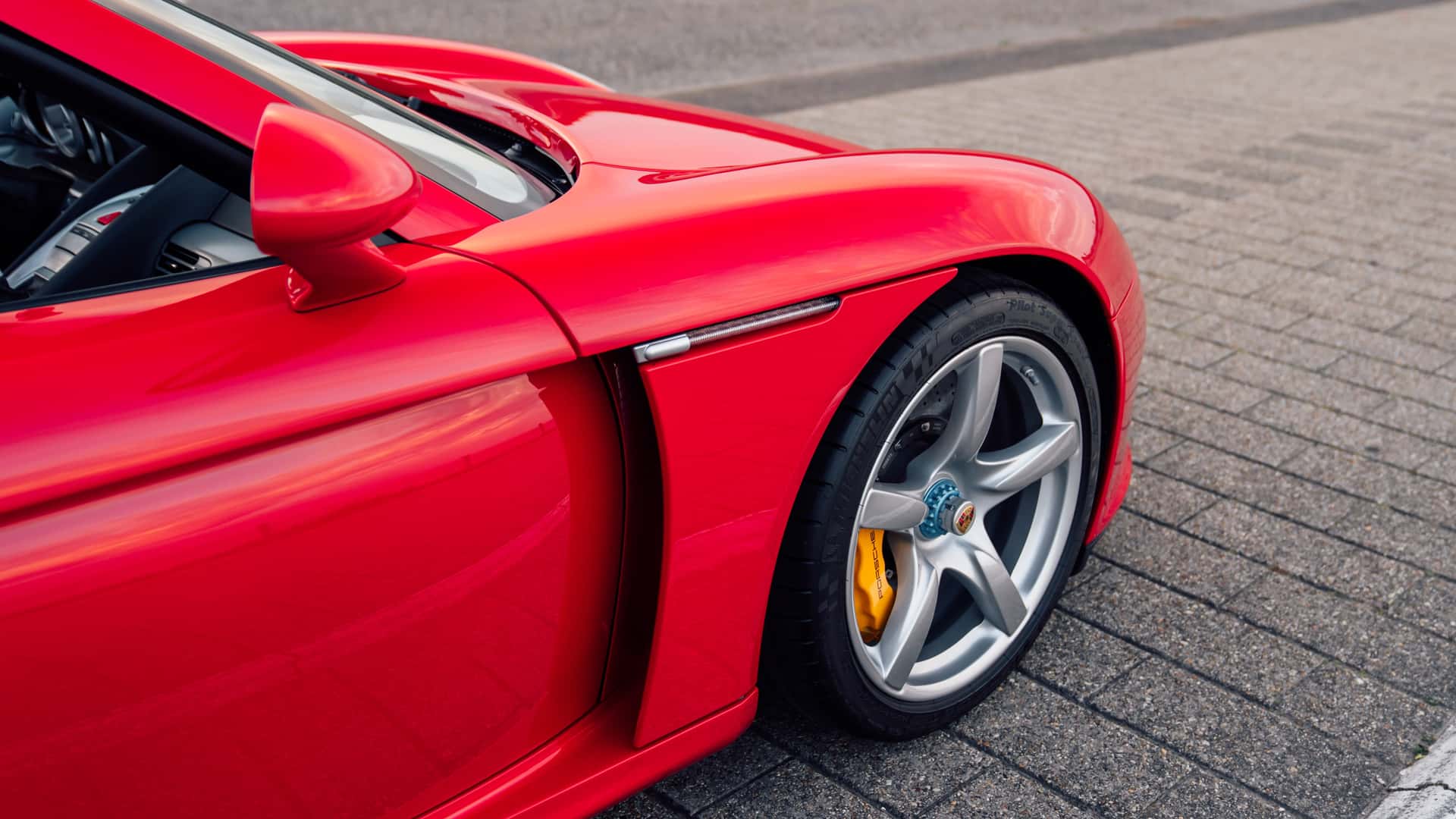Side profile view of Porsche Carrera GT Rs in Guards Red